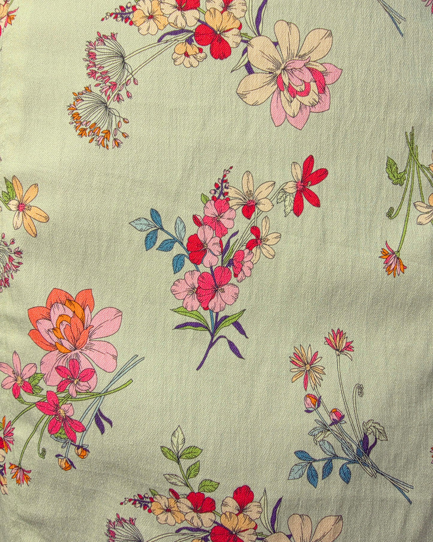 A close-up of a light sage green fabric with a colorful floral print featuring pink, red, orange, and cream flowers with green and blue leaves. Ruby De Vine ladies pencil skirt handmade on the Gold Coast featuring a 1950s-inspired fitted silhouette with back split and rear zip. Now available on Rockabilly Australia.