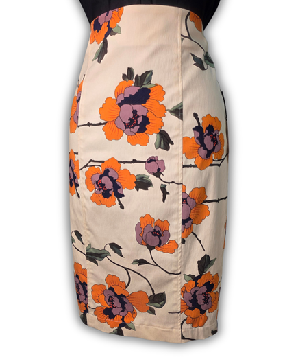 A knee-length pencil skirt with a vintage floral print on a beige background, featuring large orange and purple flowers with dark green leaves and black stems.

Ruby De Vine ladies pencil skirt handmade on the Gold Coast featuring a 1950s-inspired fitted silhouette with back split and rear zip. Now available on Rockabilly Australia.