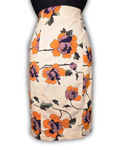 A knee-length pencil skirt with a cream base and a bold floral print featuring orange, purple, and black flowers with green leaves. 

Ruby De Vine ladies pencil skirt handmade on the Gold Coast featuring a 1950s-inspired fitted silhouette with back split and rear zip. Now available on Rockabilly Australia.