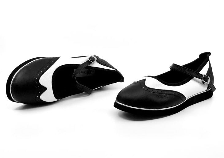 Ladies black & white classic wingtip style rock'n'roll dance flats by My Juju Dance Fever.   Hand crafted with carefully selected genuine leather for upper and inner   Single strap with elastic buckle for a stronger hold and added movement   Elegant, closed-toe wingtip design   Flat cushioned, smooth rubber sole enables you to dance on all surface types!  Super lightweight for fast movements on the dance floor.  Gel innersole for long lasting cushioned support   Stylish & comfortable design with fantastic v